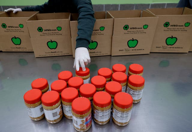 <p>A volunteer packs peanut butter into emergency distribution boxes </p>