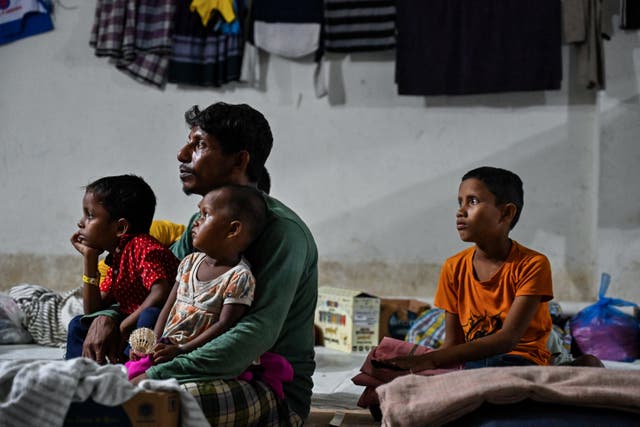 <p>Rohingya refugees gather at a temporary shelter in the basement of a government building </p>