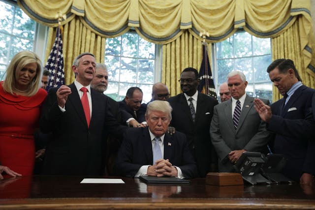 <p>Donald Trump, Mike Pence and faith leaders say a prayer during the signing of a proclamation in the Oval Office in 2017 </p>