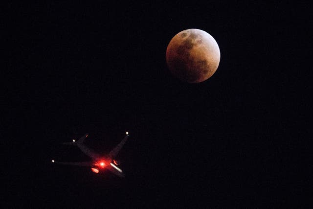 <p>A plane is seen next to the “super blue blood Moon” in Hong Kong on January 31, 2018</p>