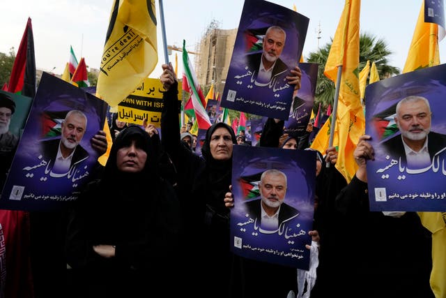 <p>Iranian protesters wave Iranian, Palestinian and Lebanon’s militant Hezbollah group flags in a demonstration to condemn killing of Hamas leader Ismail Haniyeh</p>