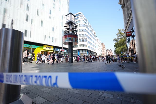 <p>Police officers at the scene in Leicester Square, London, as a man has been arrested after an 11-year-old girl and 34-year-old woman were stabbed</p>