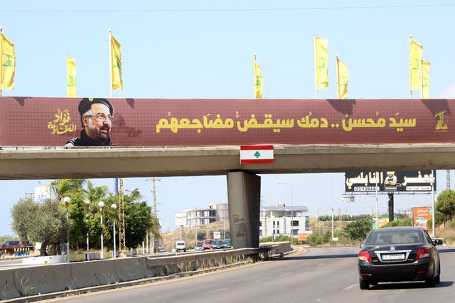 <p>Yellow Hezbollah party flags are erected along with a banner showing assassinated Hezbollah top commander Fuad Shukr, placed along a walk way across the Sidon-to-Tyre highway, in southern Lebanon </p>