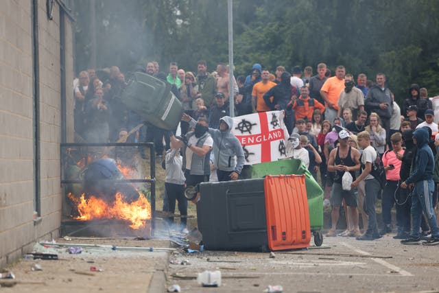 <p>A large mob gathers outside the Holiday Inn Express in Manvers, a suburb in Rotherham, before hurling debris at police on Sunday </p>