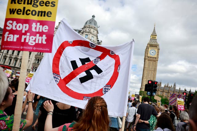 <p>People hold anti-fascist banners as they participate in a "Stop the Far-right" march to Westminster (Photo by BENJAMIN CREMEL / AFP) (Photo by BENJAMIN CREMEL/AFP via Getty Images)</p>